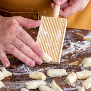 Potato Gnocchi being rolled down a gnocchi board (free with potato ricer)