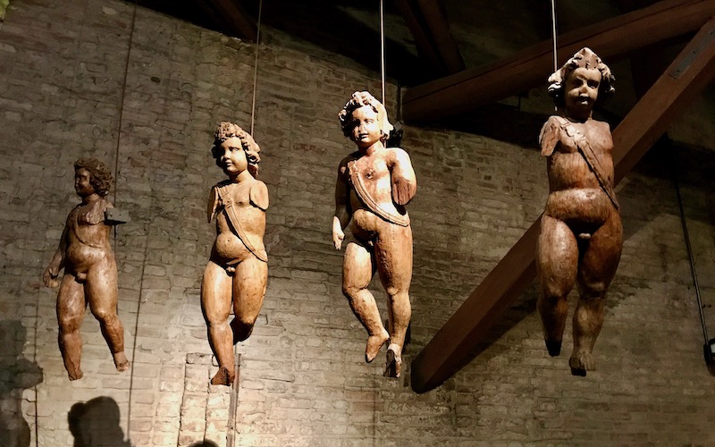 Wooden cherubs hanging from the ceiling at Farnese Theatre - Parma Food Tour