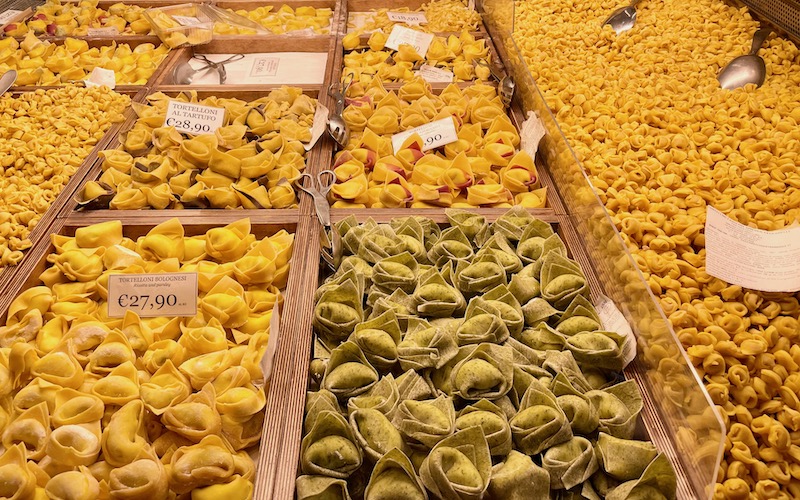 Trays of fresh yellow and green pasta in a shop in the Bologna Market - Bologna Food Tour