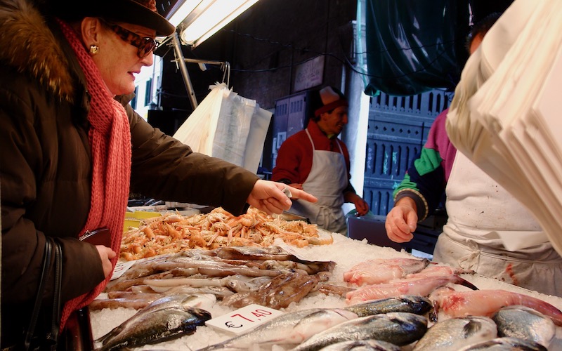 Lady selecting fish at Rialto Market Venice - Walking Tour of Italian Food Markets