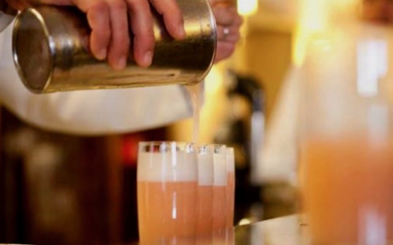 Barman pouring bellinis into glasses at Harry's Bar - Venice Cheap Eats