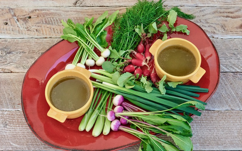 Bagna Cauda (Bagna Càuda) on a red platter with colourful baby vegetables