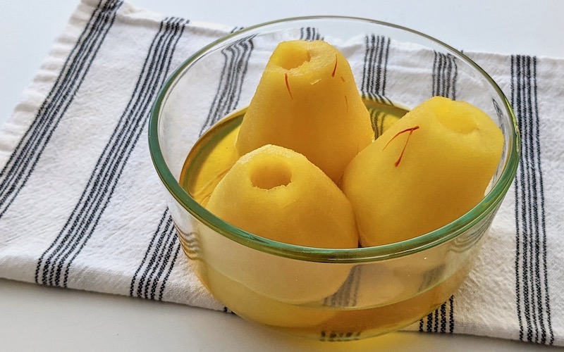 Saffron Poached Pears in glass bowl on black and white cloth