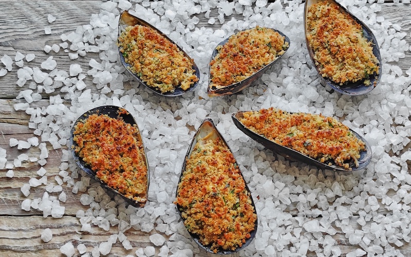 Cozze Gratinate (mussels au gratin) on a bed of rock salt