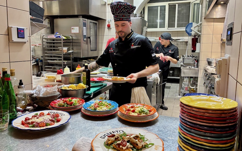 Chef plating food on colourful ceramics at Umberto 1916 Naples - Campania Food Lovers’ Guide